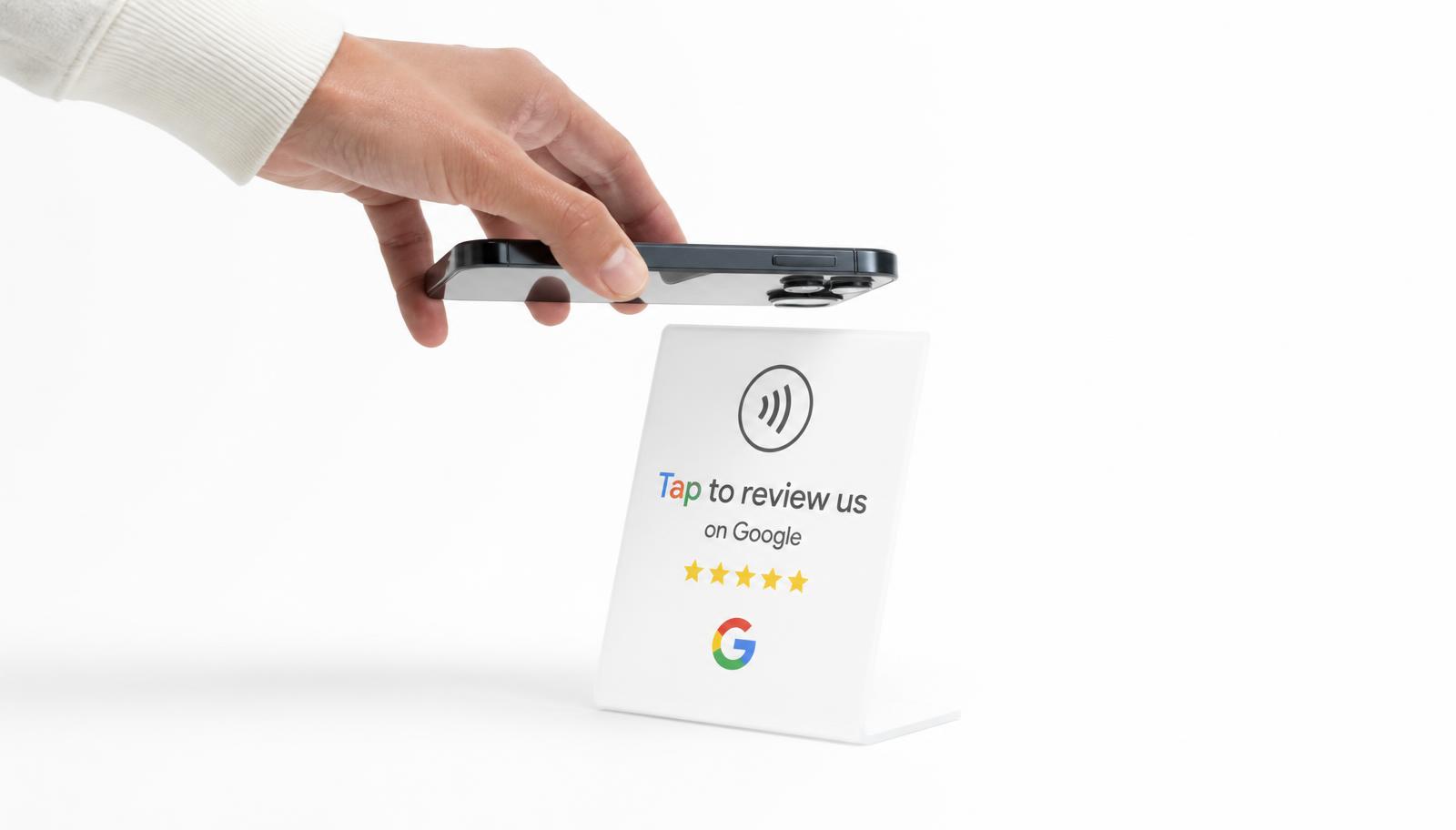 A phone tapping a white acrylic NFC Google review stand
